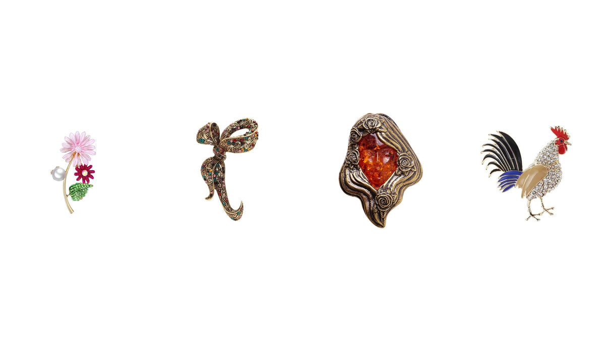 Quatre broches au style ancien : fleur perlée, nœud orné de strass, ambre sculpté et coq émaillé