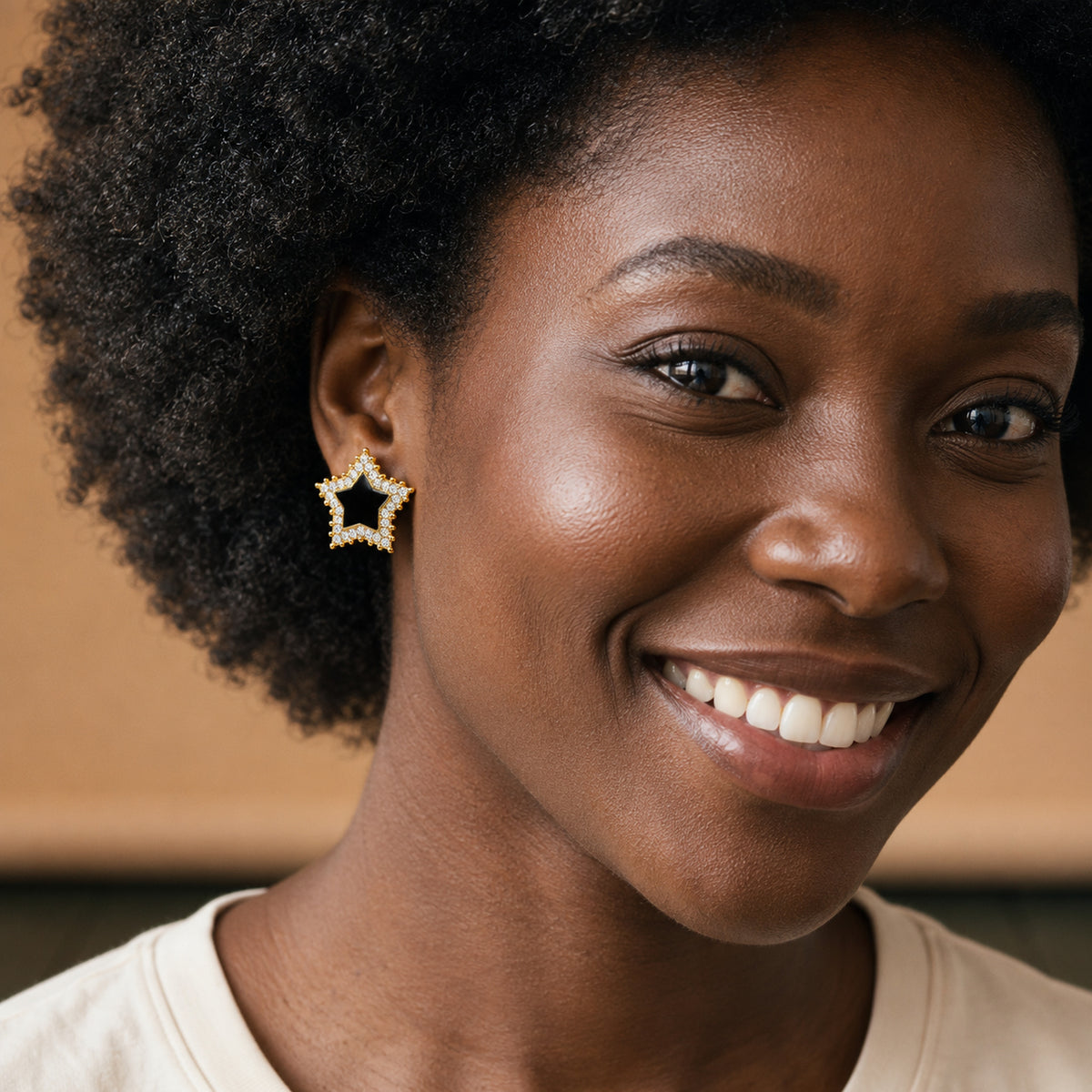 Boucles d'oreilles clips noires et dorées à strass portées en studio par une femme, portrait rapproché Bild