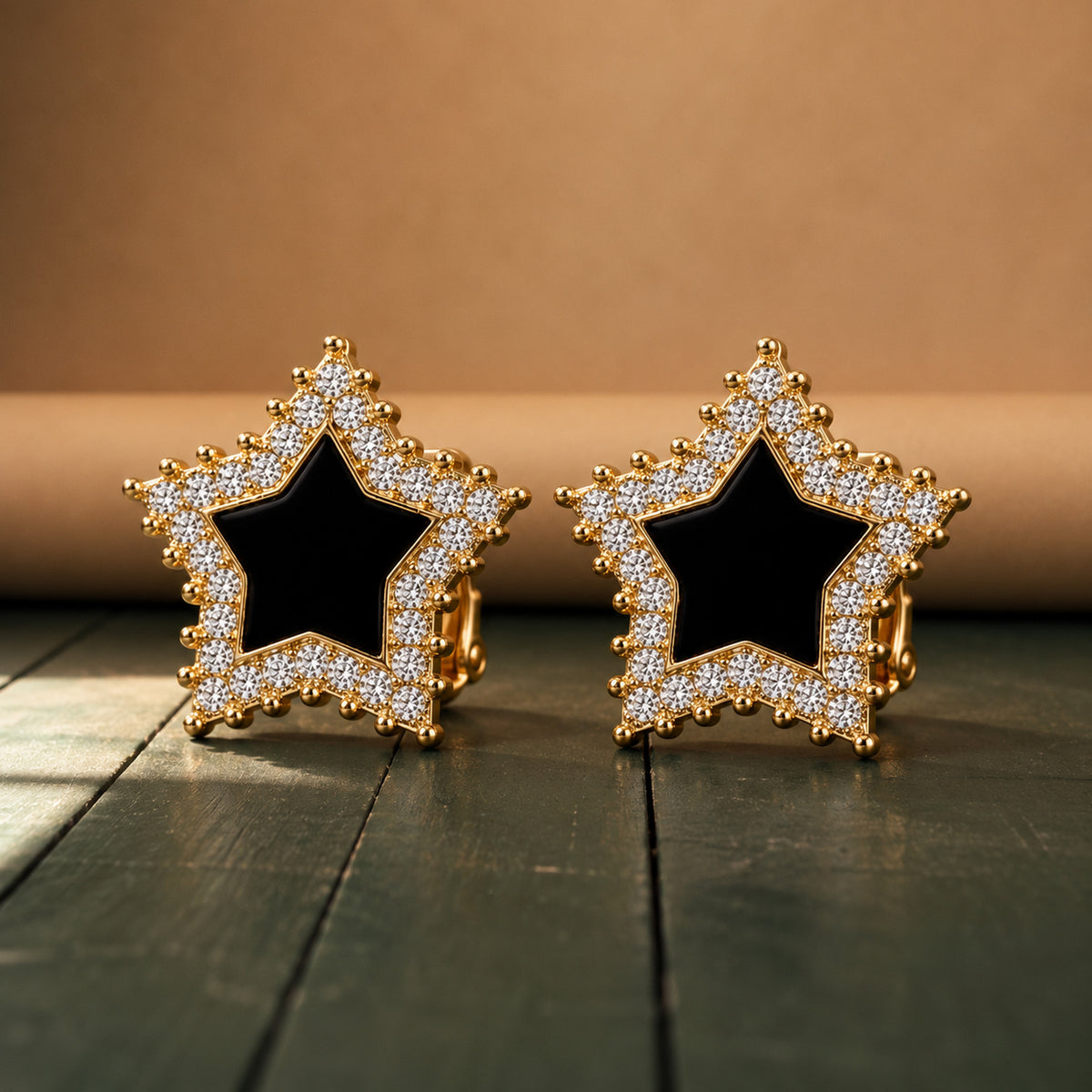 Gros plan sur les strass et le centre noir des boucles d'oreilles clips dorées Bild