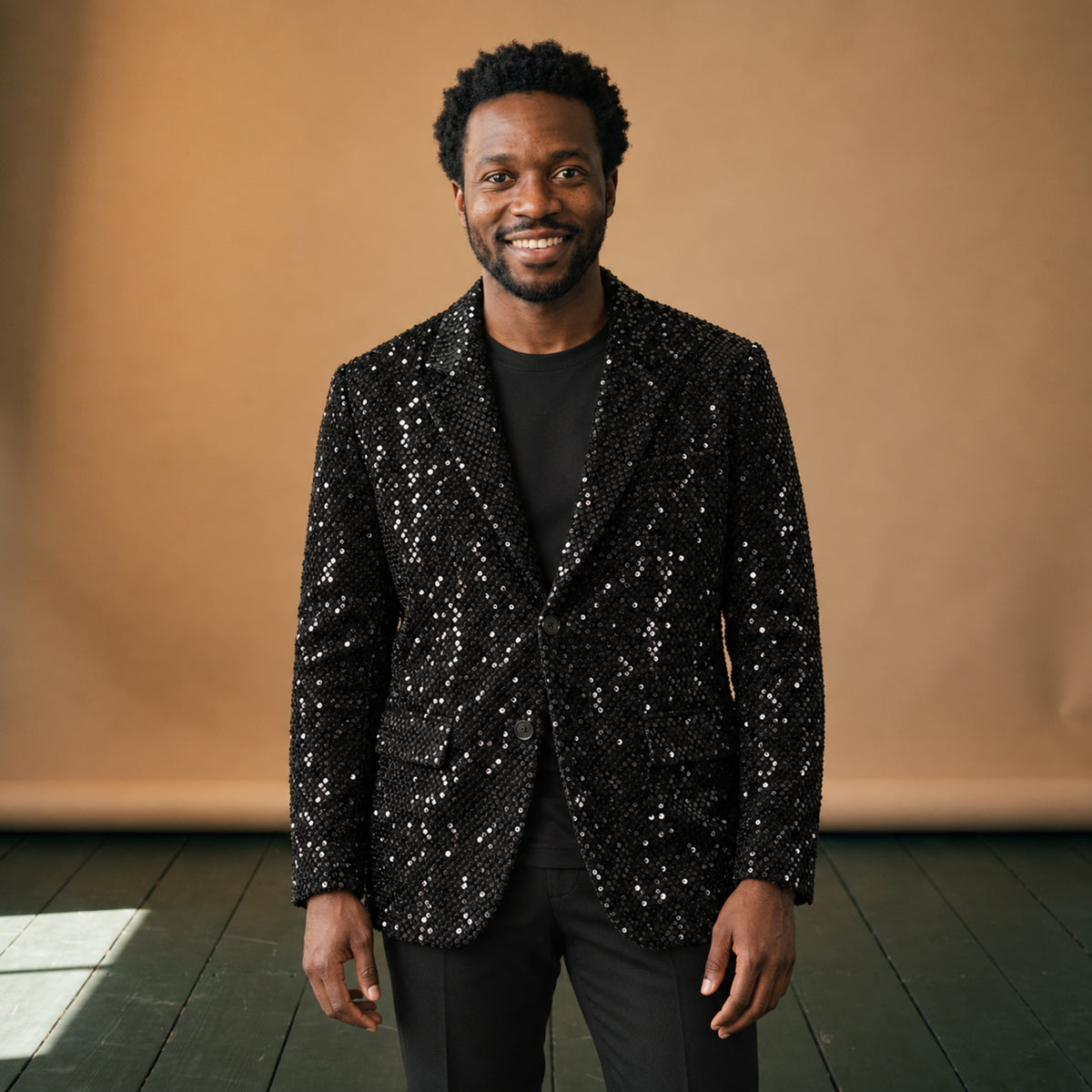 Veste disco homme à sequins noirs portée en studio sur une chemise noire, vue de face Bild
