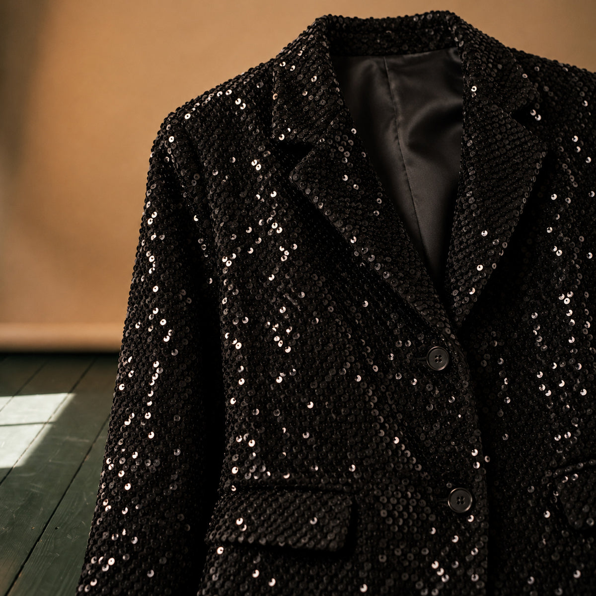 Gros plan sur les sequins noirs et le col tailleur de la veste disco homme Bild