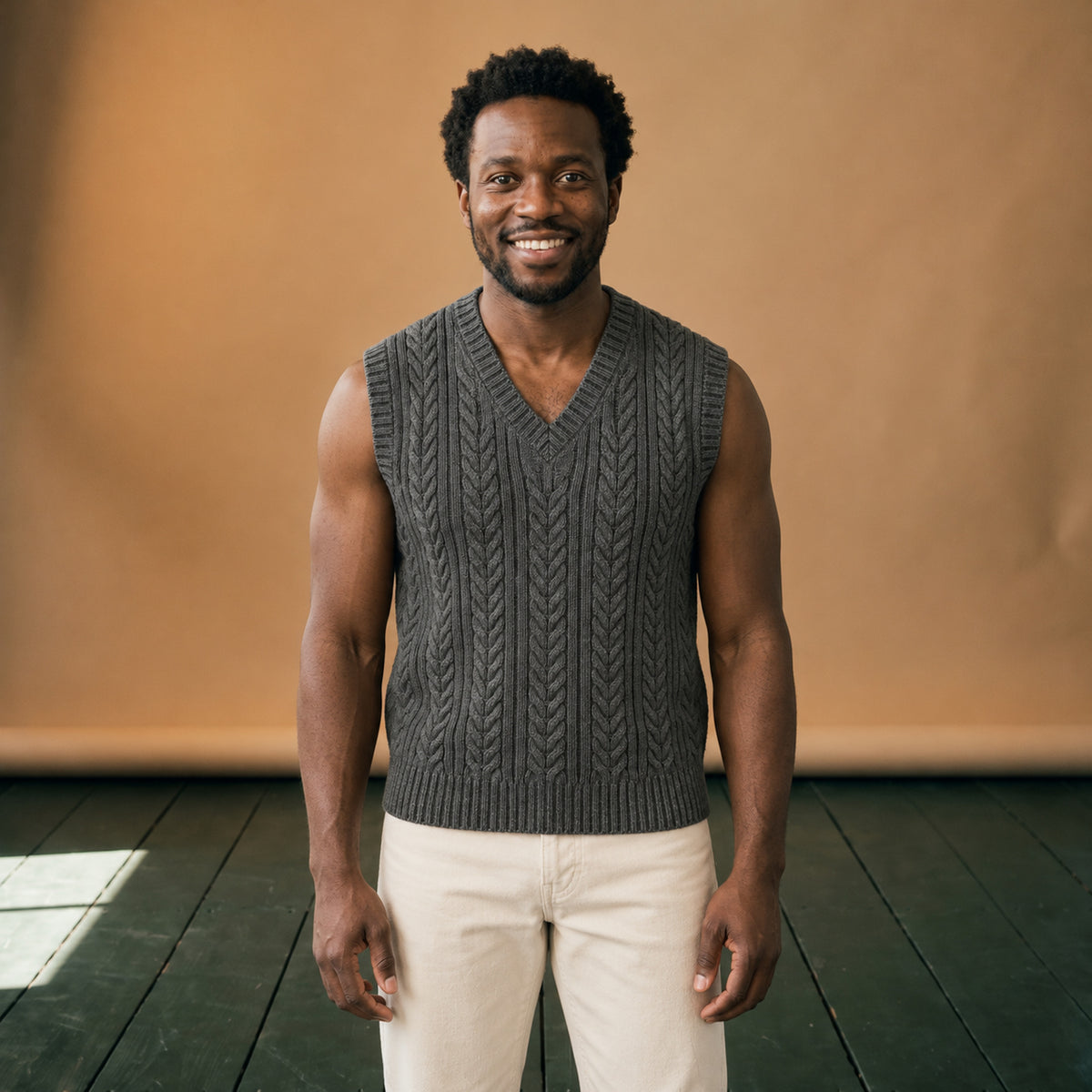 Gilet tricoté col V homme sans manches à torsades porté en studio sur une chemise, vue de face Bild