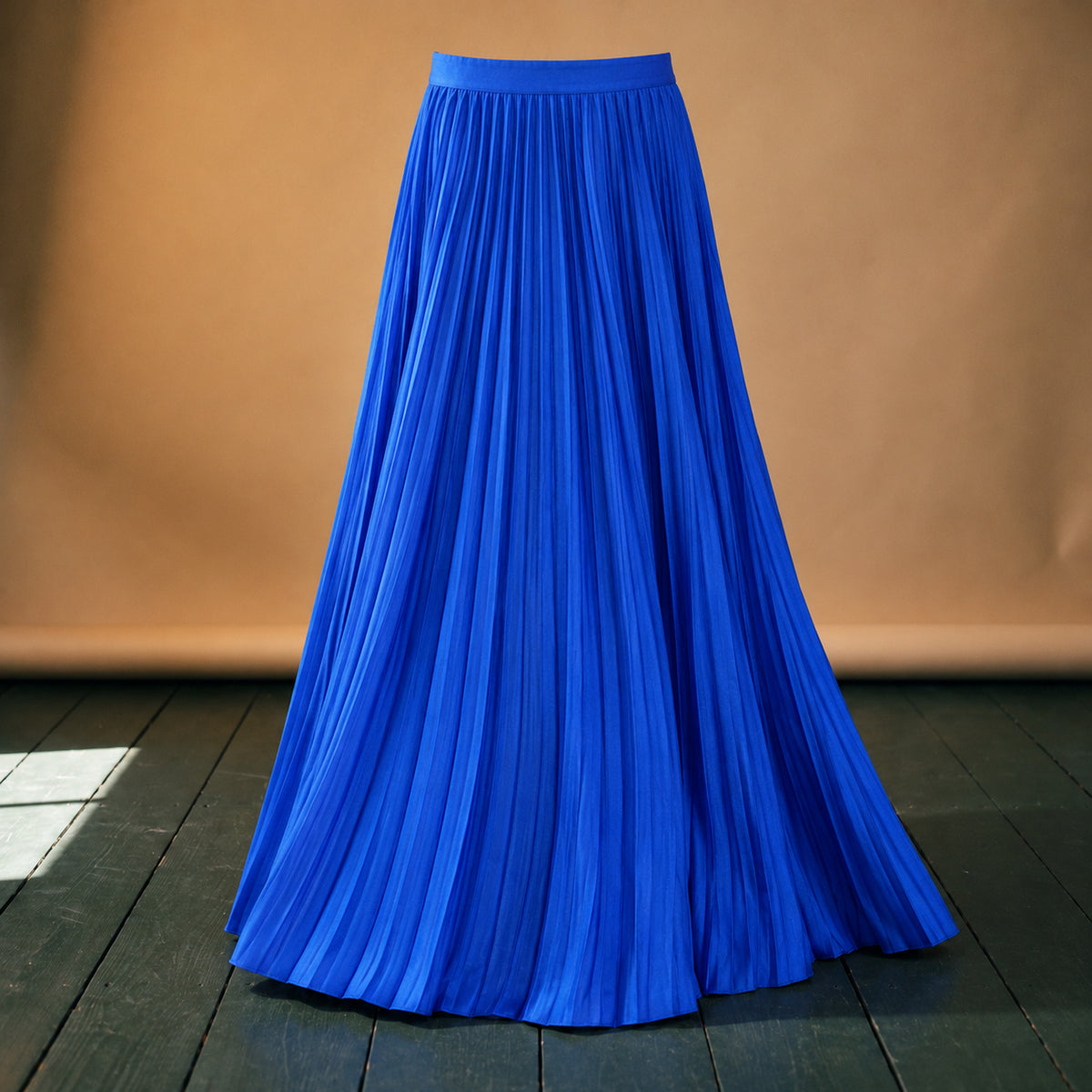 Gros plan sur les plis, le bleu roi uni et la taille élastique de la jupe longue plissée bleue style années 80 Bild