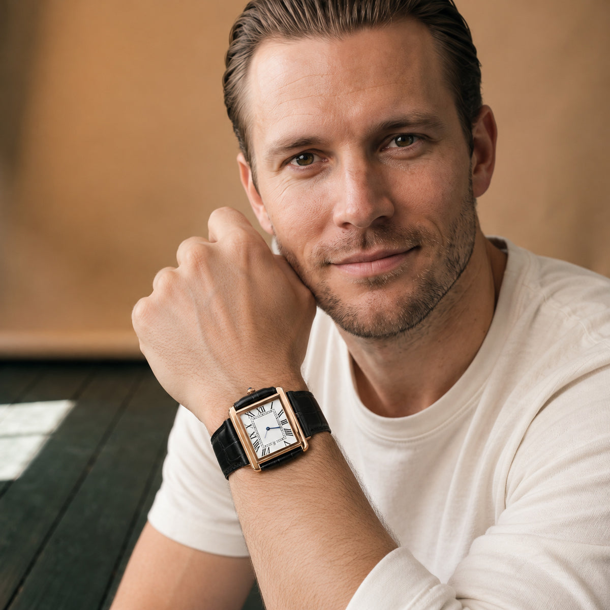 Montre rectangulaire homme cadran blanc portée au poignet, bracelet noir effet cuir, vue en studio Bild