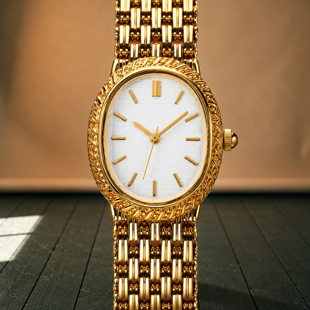 Gros plan sur la maille dorée et le cadran blanc à index dorés de la montre vintage femme Bild