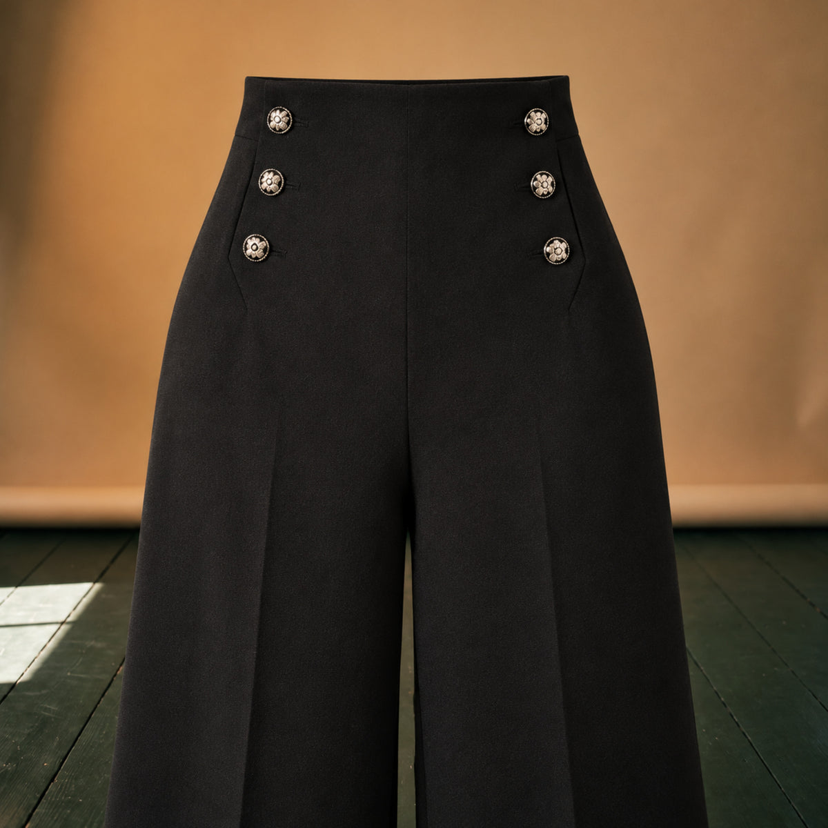 Gros plan sur les boutons décoratifs et la ceinture du pantalon taille haute femme Bild