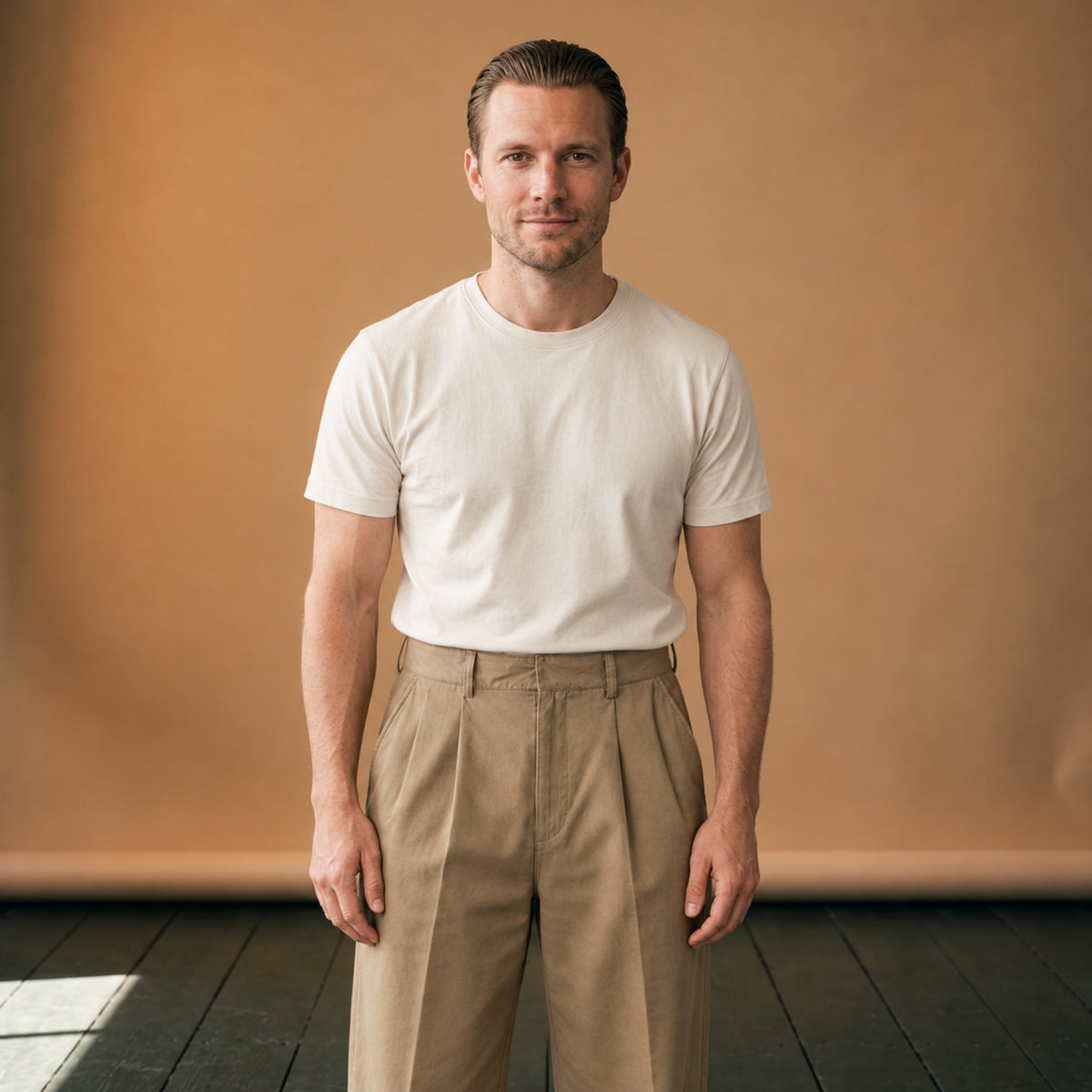 Pantalon vintage homme coupe droite années 30 porté en studio avec une chemise rentrée, vue de face Bild