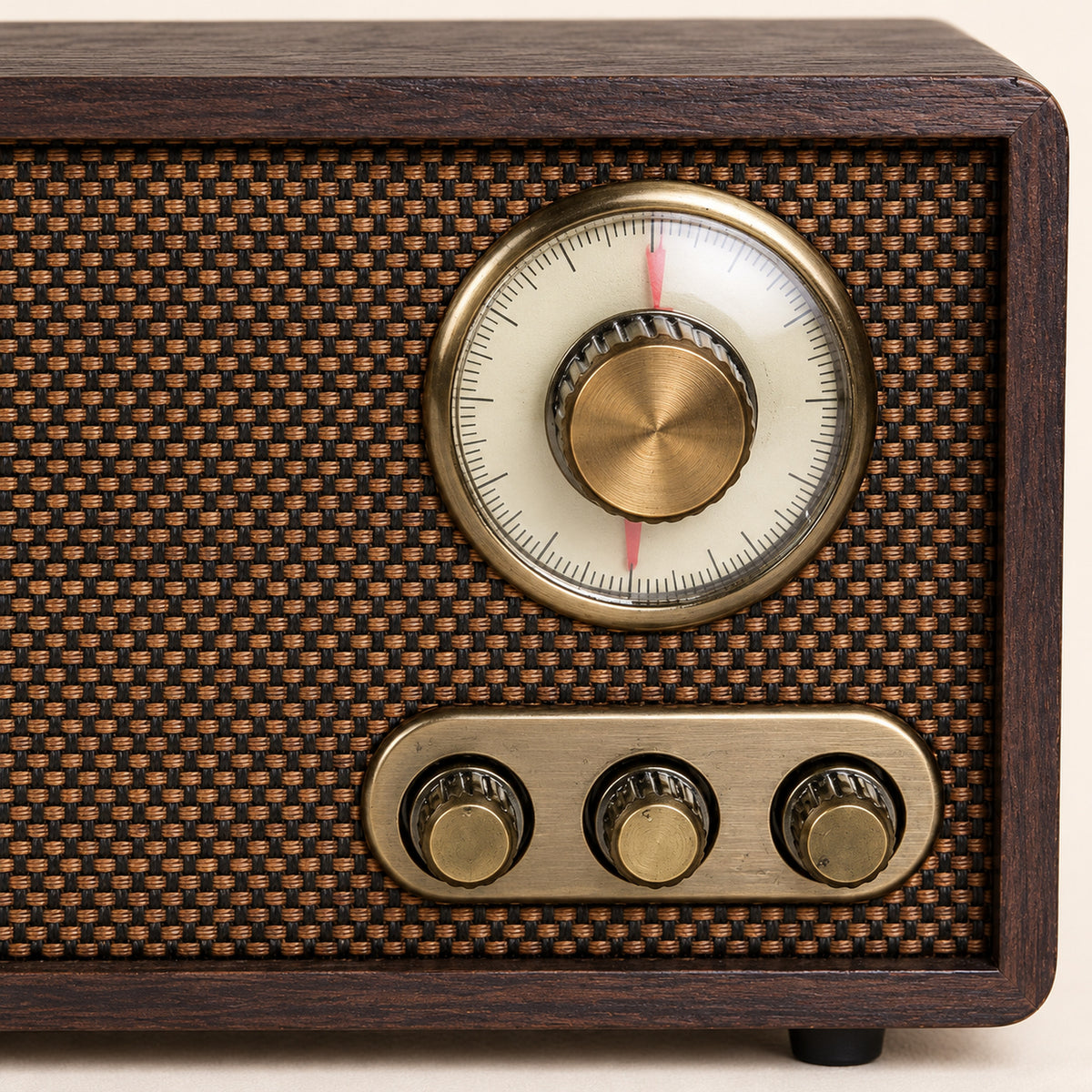 Gros plan sur le cadran rond à aiguille, les boutons dorés et le tissu tressé de la radio vintage bluetooth en bois Bild