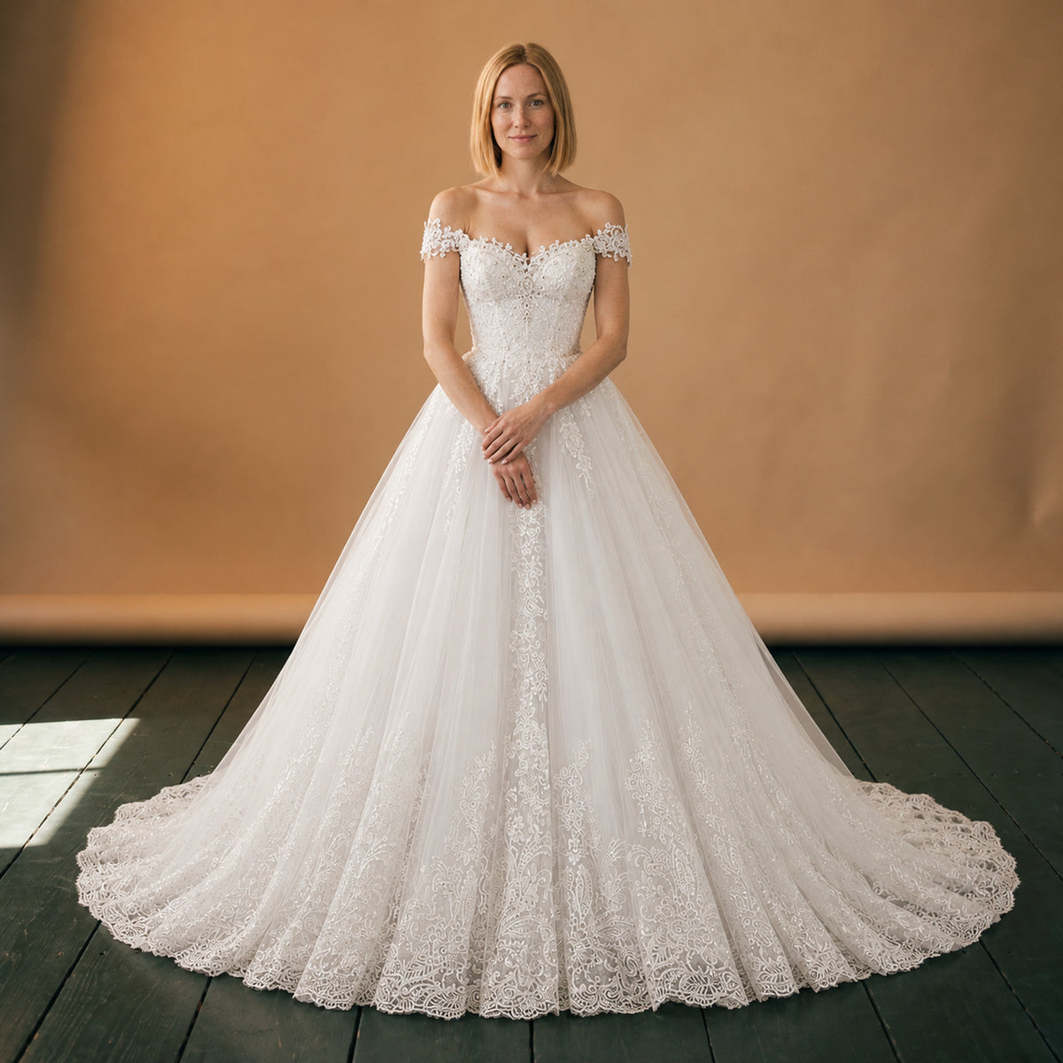Robe charleston blanche de mariage en dentelle portée en studio, épaules dénudées et traîne, vue de face Bild