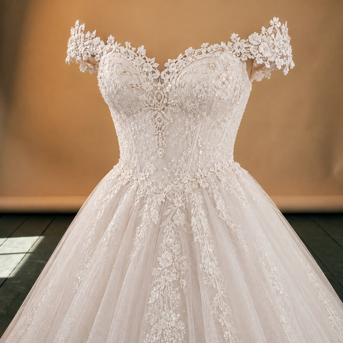 Gros plan sur la dentelle brodée du bustier et de la traîne de la robe charleston blanche de mariage Bild