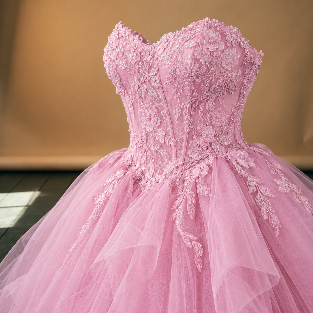 Gros plan sur les appliqués fleuris du bustier et la jupe vaporeuse de la robe charleston mariage ado rose Bild