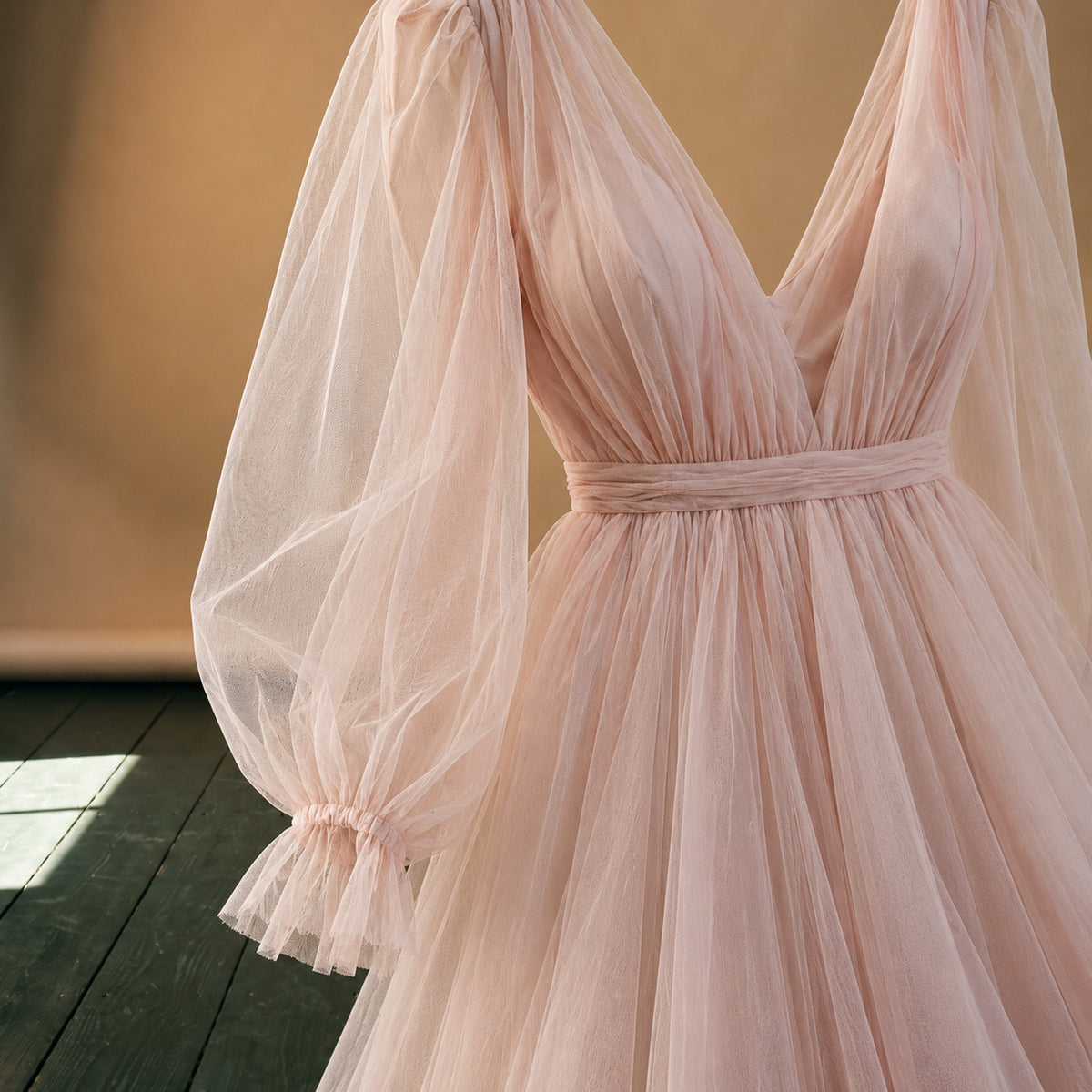 Gros plan sur la manche bouffante en voile et le buste froncé de la robe charleston mariage rose poudré Bild
