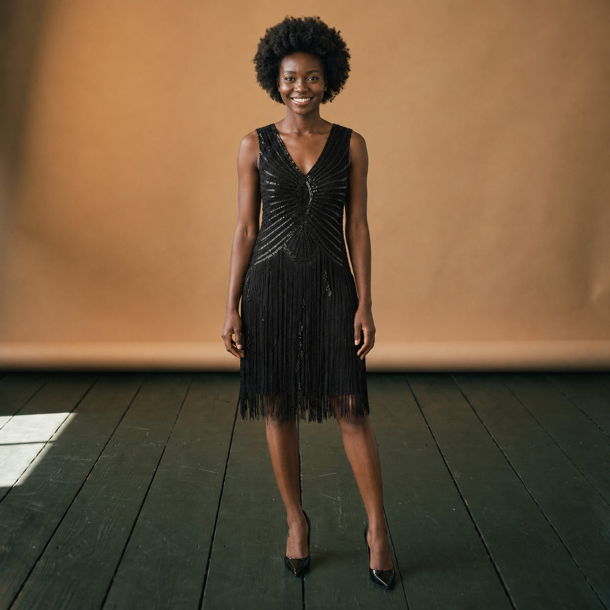 Robe charleston à paillettes et franges esprit années 20 portée en studio, vue en pied Bild