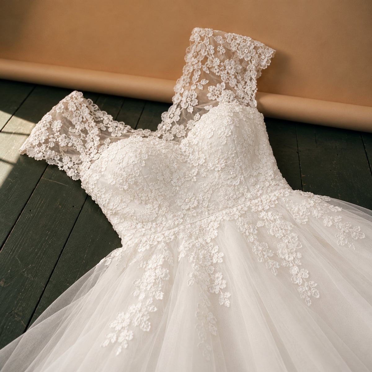 Gros plan sur la dentelle du corsage et le tulle de la jupe de la robe de mariée courte Bild