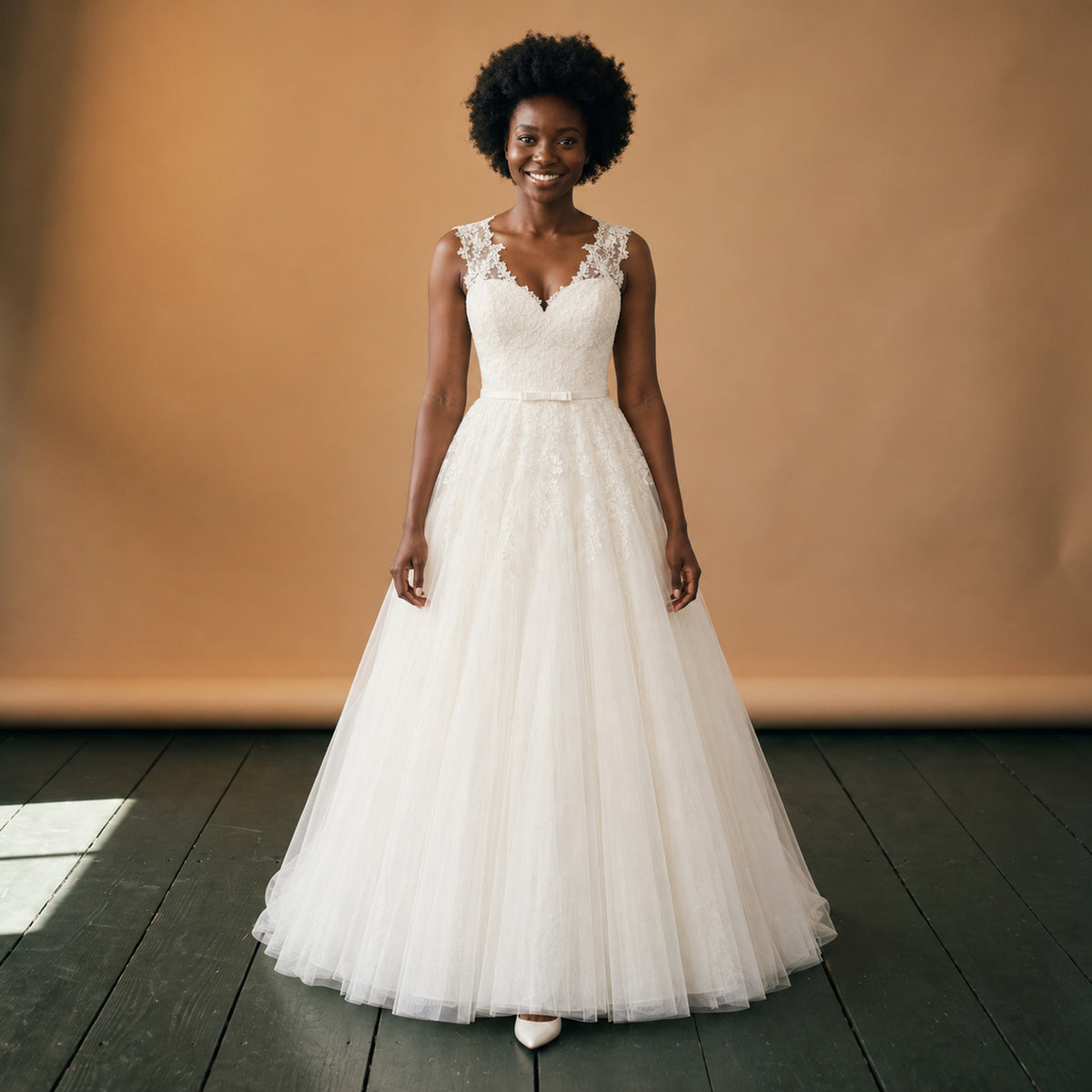 Robe de mariée courte vintage en dentelle et tulle portée en studio, vue en pied de face Bild