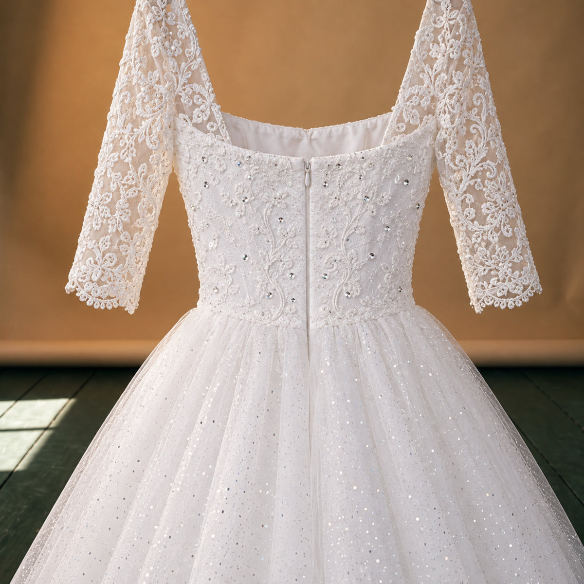 Gros plan sur les perles, paillettes et broderies de la robe de mariée vintage en dentelle à manches mi-longues Bild