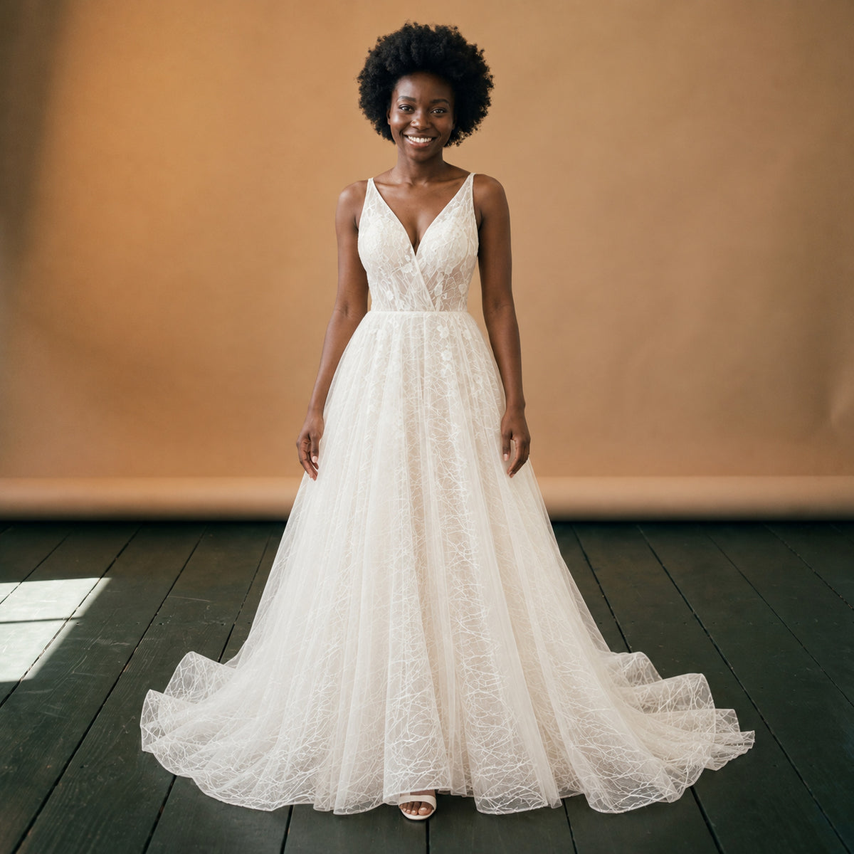 Robe de mariée vintage chic en tulle à dos nu portée en studio, décolleté en V, vue de face Bild