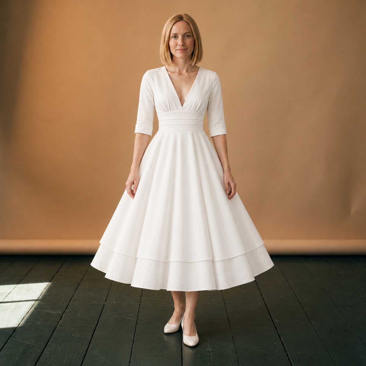 Robe de mariée vintage style années 50 à jupe ample portée en studio, décolleté en V, vue de face Bild