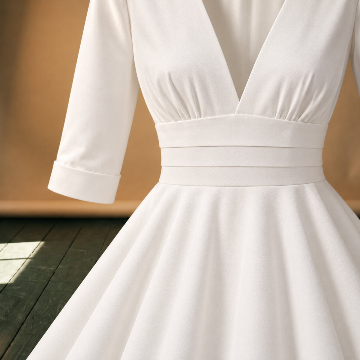 Gros plan sur le satin de polyester et le décolleté en V de la robe de mariée vintage années 50 Bild