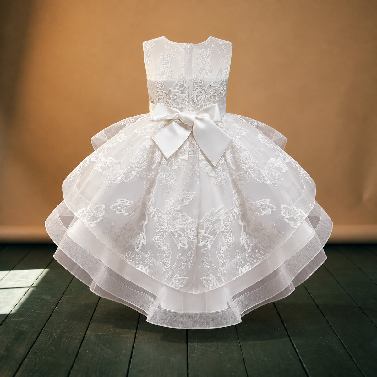 Robe de mariage petite fille style charleston blanche portée en studio par une fillette, jupe à volants, vue de face Bild
