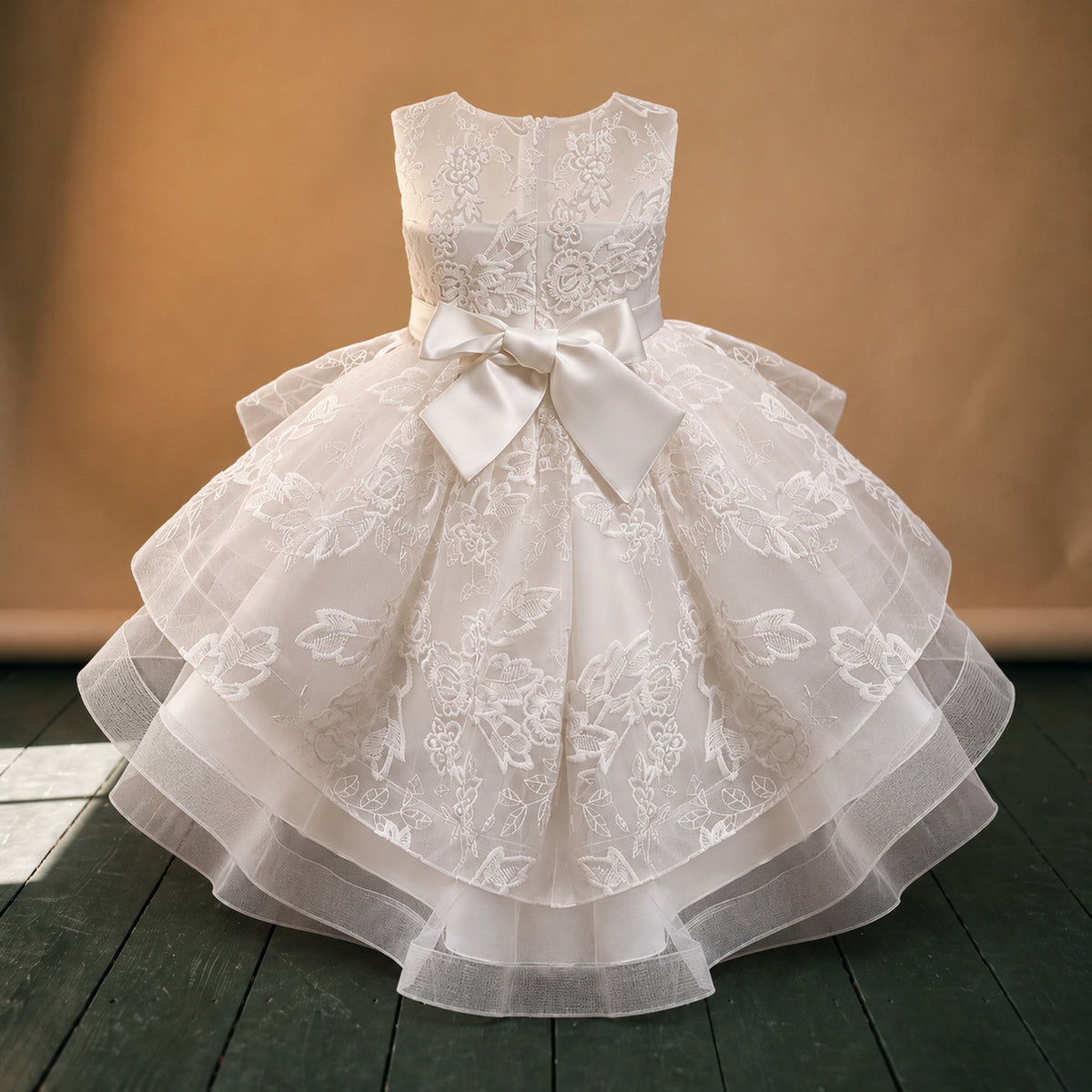 Gros plan sur les broderies fleuries et les volants de la robe de mariage petite fille style charleston Bild