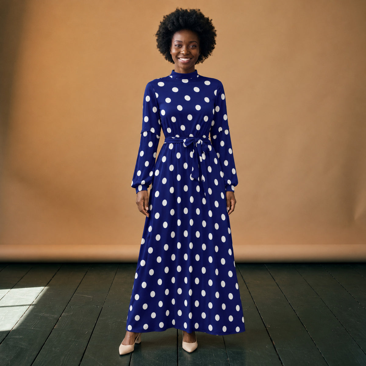 Robe maxi années 80 à pois bleus et col roulé portée en studio, longueur chevilles, vue de face Bild