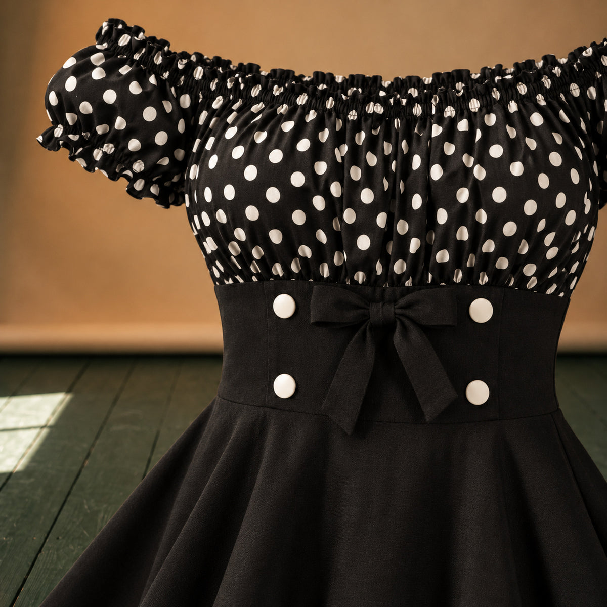 Gros plan sur le bustier à pois blancs et les boutons de la robe pin-up noire et blanche Bild