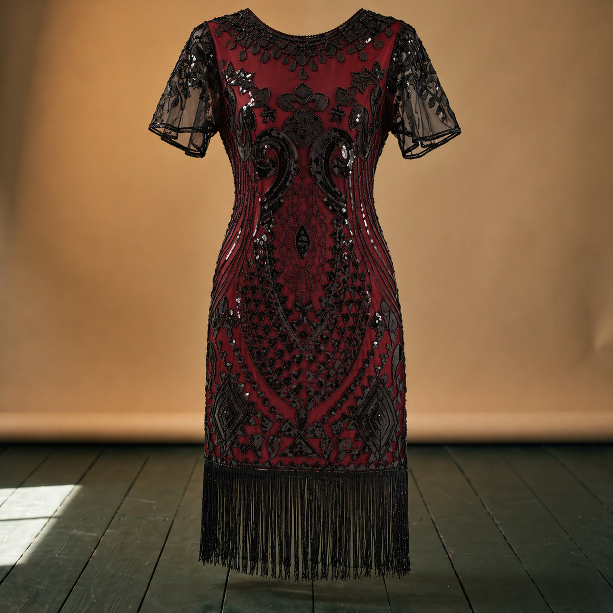Gros plan sur les sequins, les perles brodées et les franges de la robe style charleston pour mariage Bild