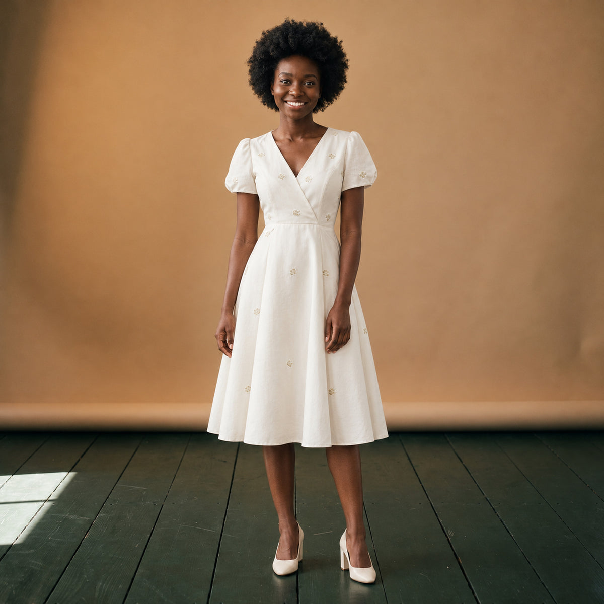 Robe style charleston blanche pour mariage portée en studio, longueur au-dessus du genou, vue de face Bild