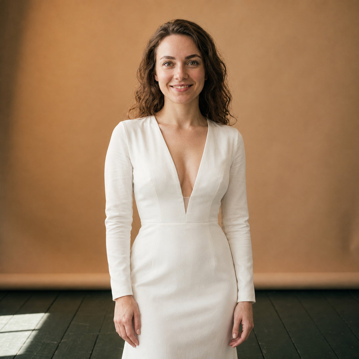 Robe de mariage vintage années 50 en satin blanc portée en studio, col V et manches longues Bild