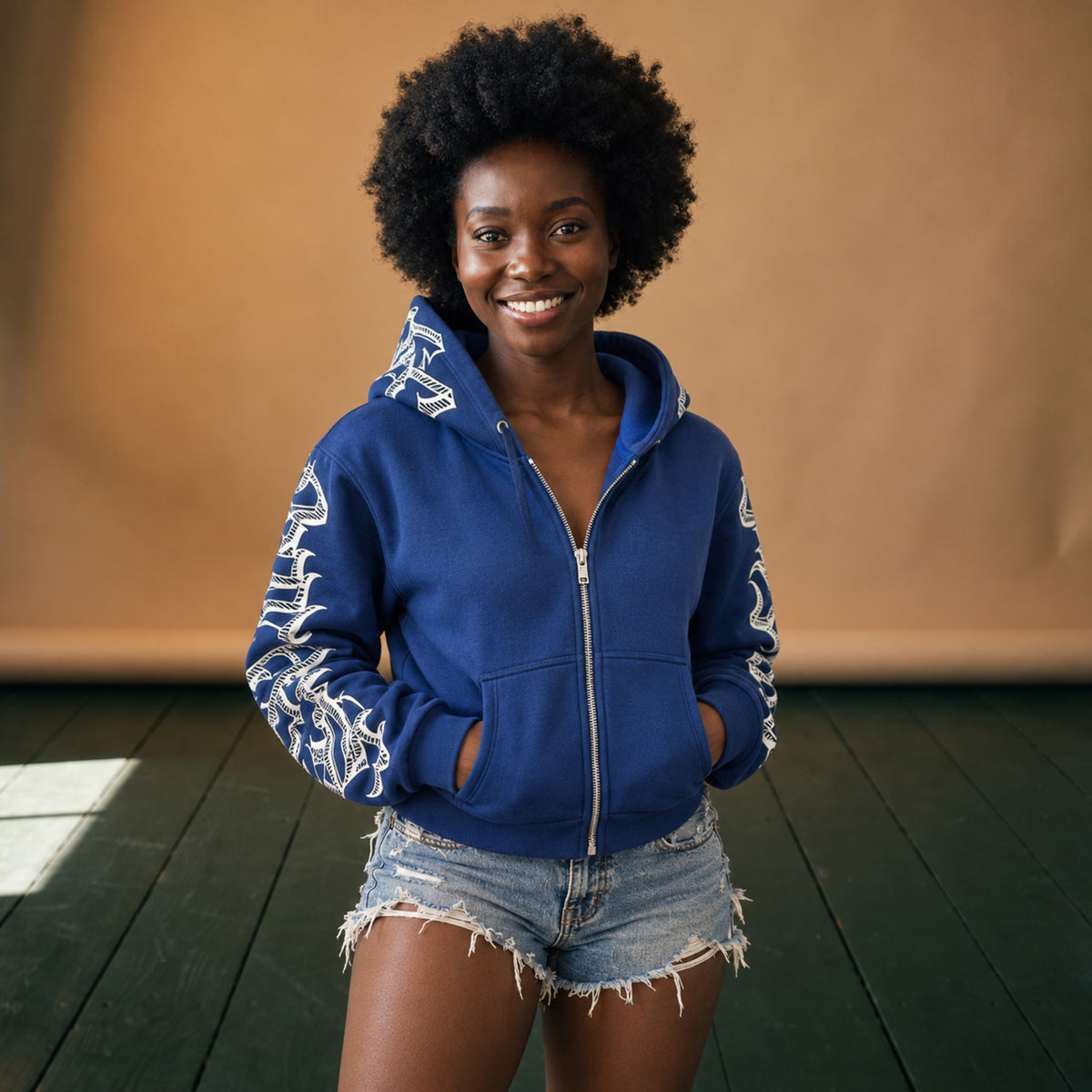 Sweat à capuche femme vintage bleu zippé à lettrage blanc porté en studio, capuche relevée Bild