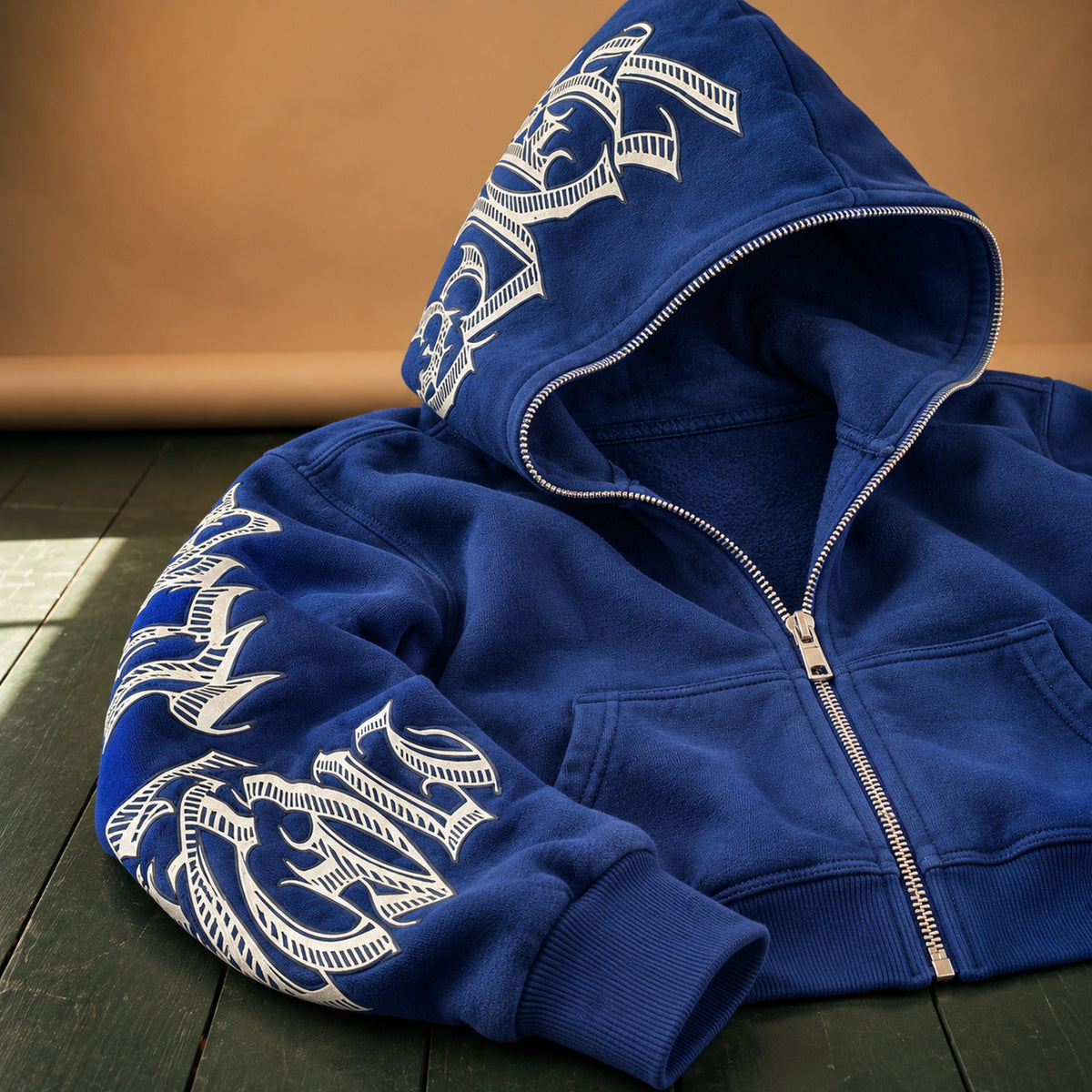 Gros plan sur le lettrage blanc imprimé et la fermeture éclair du sweat à capuche femme vintage bleu Bild