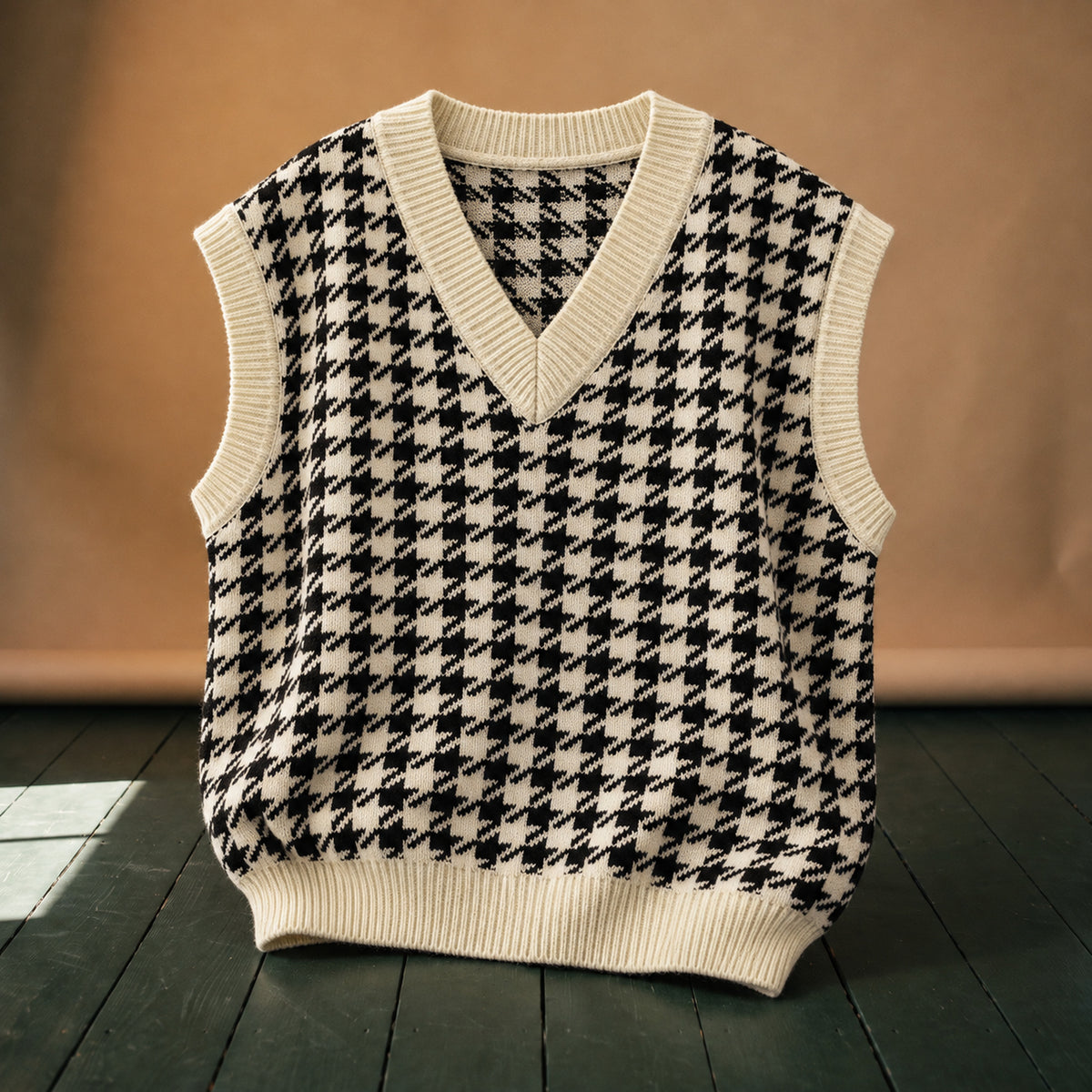 Gros plan sur la maille pied-de-poule noir et blanc et les côtes du col V du sweat vintage femme sans manches Bild